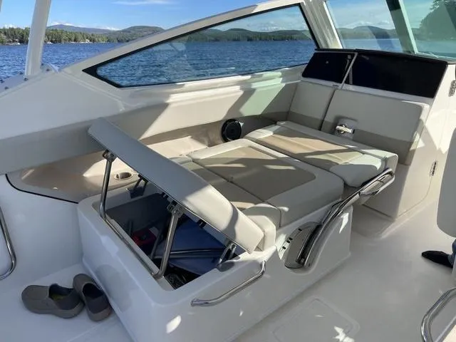 Slide: The Image of 2024 Boston Whaler 280 Vantage interior with adjustable seating, on a scenic lake. - 42