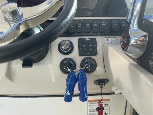 Slide: The Image of 2024 Boston Whaler 280 Vantage helm with steering wheel, controls, and key switches. - 43
