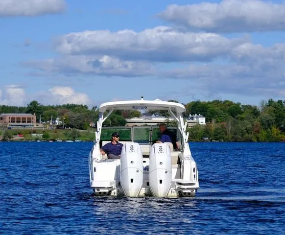 Slide: The Image of 2024 Boston Whaler 280 Vantage boat cruising on a lake under a partly cloudy sky. - 6