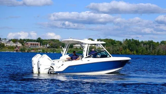 Slide: The Image of 2024 Boston Whaler 280 Vantage cruising on a lake under a partly cloudy sky. - 7