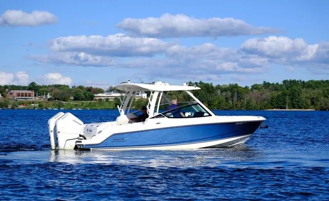 Slide: The Image of 2024 Boston Whaler 280 Vantage boat cruising on a lake under a clear blue sky. - 8