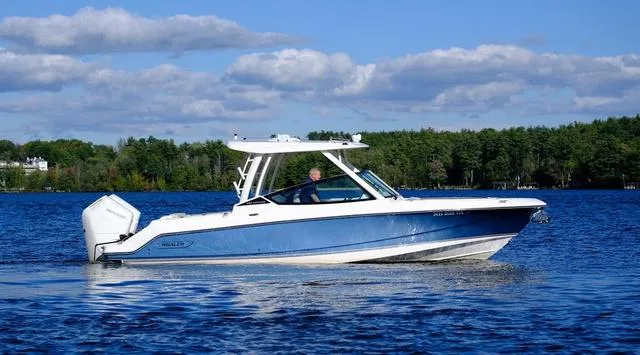 Slide: The Image of 2024 Boston Whaler 280 Vantage boat cruising on a lake under a clear blue sky. - 9
