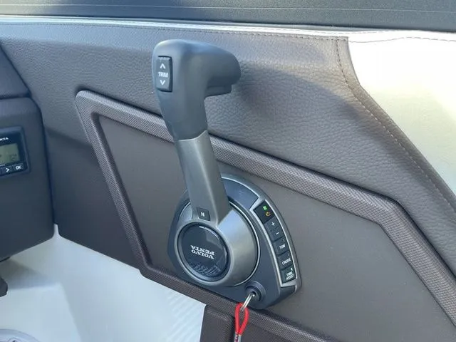 Slide: The Image of 2022 Cobalt R4 boat throttle control with trim buttons and leather panel. - 13