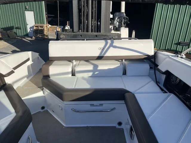 Slide: The Image of 2022 Cobalt R4 boat interior with white and brown seating, docked near green building. - 18