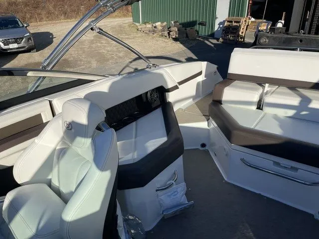 Slide: The Image of 2022 Cobalt R4 boat interior with white and brown seating, parked outdoors. - 19