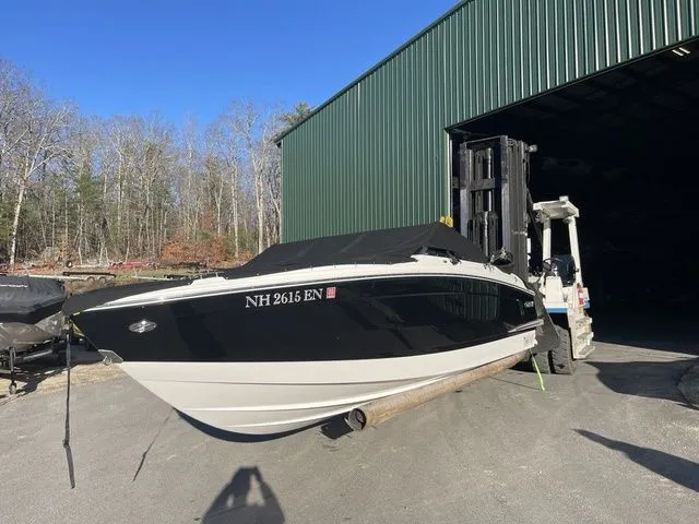 Slide: The Image of 2022 Cobalt R4 boat on forklift near green warehouse, outdoors. - 2