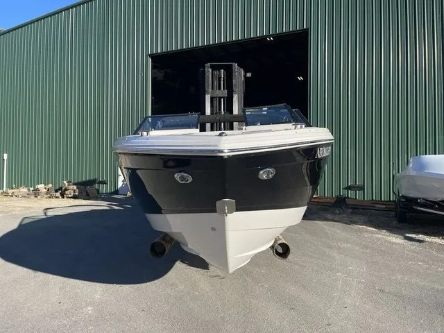 Slide: The Image of 2022 Cobalt R4 boat in front of a green warehouse, parked on concrete. - 4