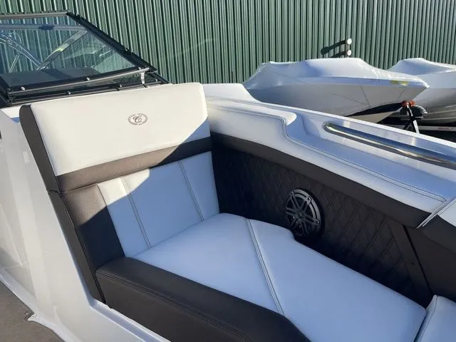 Slide: The Image of 2022 Cobalt R4 boat interior with white and black seating, near a green fence. - 8