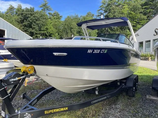 Slide: The Image of 2023 Chaparral 247 SSX boat on trailer, parked outdoors with trees in background. - 1
