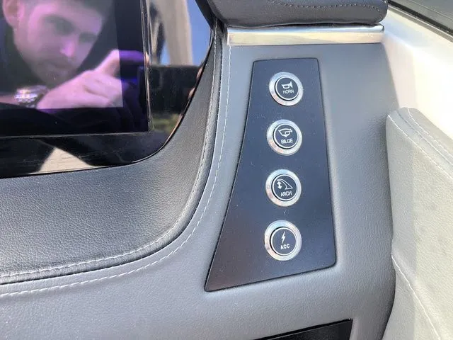 Slide: The Image of Dashboard controls of 2023 Chaparral 247 SSX boat, featuring horn, bilge, arch, and accessory buttons. - 15