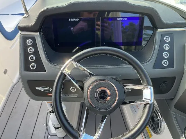 Slide: The Image of 2023 Chaparral 247 SSX boat dashboard with dual Simrad displays and sleek steering wheel. - 17