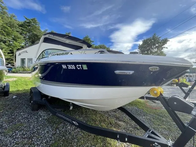 Slide: The Image of 2023 Chaparral 247 SSX boat on trailer, parked outdoors under a blue sky. - 2