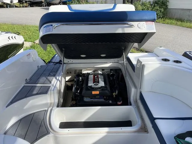 Slide: The Image of 2023 Chaparral 247 SSX boat engine compartment with open hatch, showcasing engine details. - 7