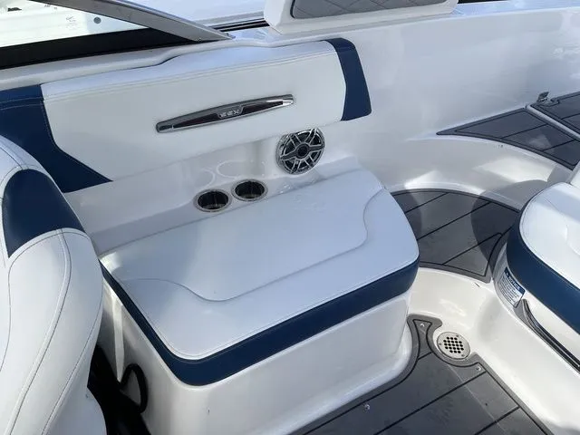 Slide: The Image of 2023 Chaparral 247 SSX boat interior with white and blue seating, cup holders, and speaker. - 9