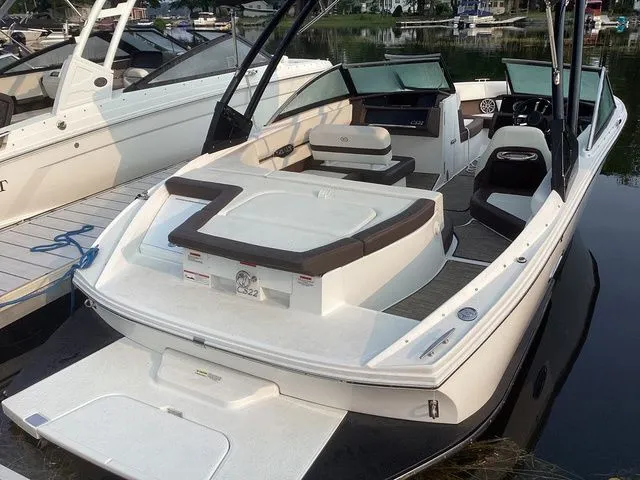 Slide: The Image of 2024 Cobalt CS22 boat docked, featuring spacious seating and sleek design. - 2