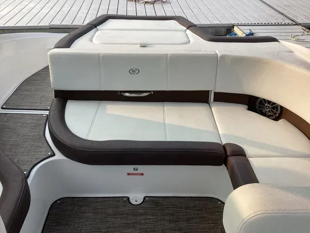 Slide: The Image of 2024 Cobalt CS22 boat interior with white and brown seating, docked on a wooden pier. - 6