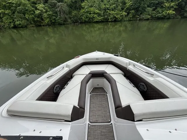 Slide: The Image of 2024 Cobalt R4 boat with spacious seating, docked on a calm lake surrounded by lush greenery. - 10