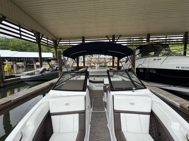 Slide: The Image of 2024 Cobalt R4 boat docked in a marina under a covered structure. - 12