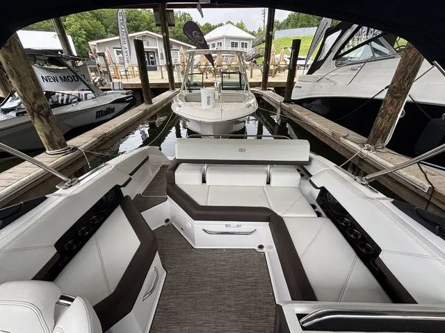 Slide: The Image of 2024 Cobalt R4 boat interior with white seating, docked at a marina. - 13