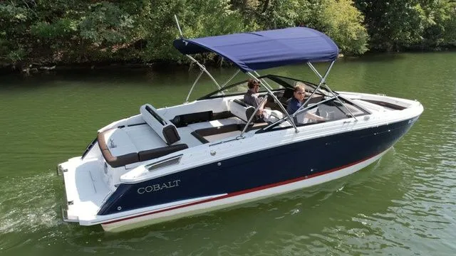 Slide: The Image of 2024 Cobalt R4 boat cruising on a serene lake with lush green surroundings. - 3