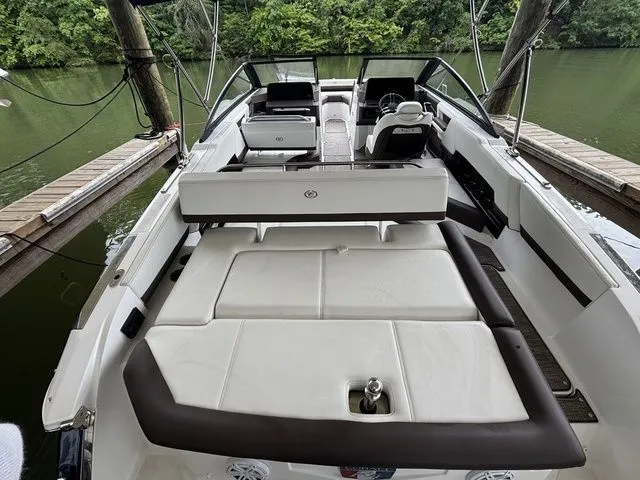 Slide: The Image of 2024 Cobalt R4 boat with spacious seating and sleek design docked by a lush riverside. - 4