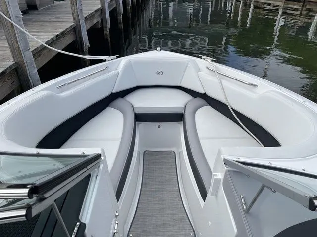Slide: The Image of 2024 Cobalt 220S boat interior with white seating, docked by wooden pier. - 15