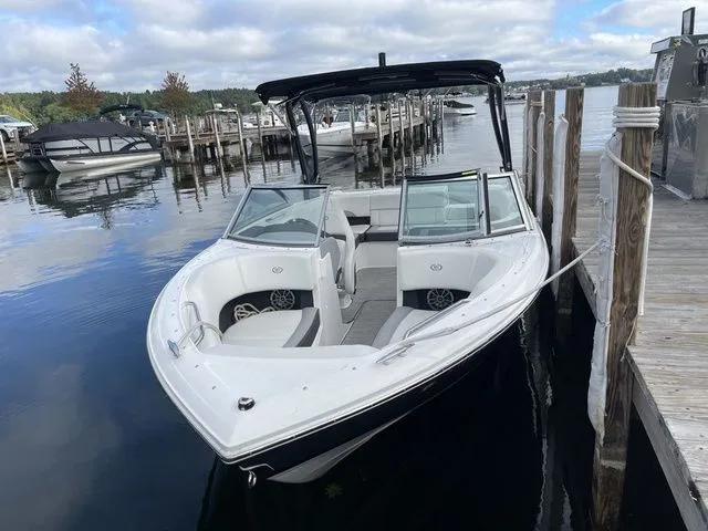 Slide: The Image of 2024 Cobalt 220S boat docked on a calm lake with clear skies. - 18