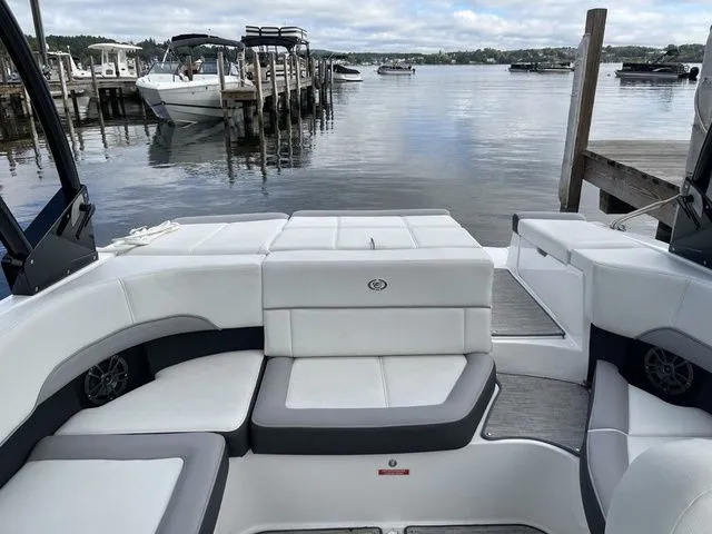 Slide: The Image of 2024 Cobalt 220S boat interior with white seating, docked by a serene lake. - 8