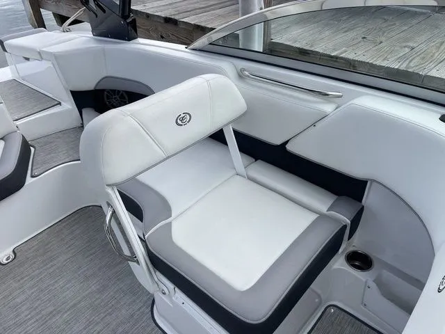 Slide: The Image of 2024 Cobalt 220S boat interior with white and gray seating, dockside view. - 9