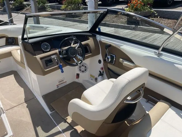 Slide: The Image of 2022 Cobalt CS23 boat interior with beige seating, steering wheel, and dashboard controls. - 10