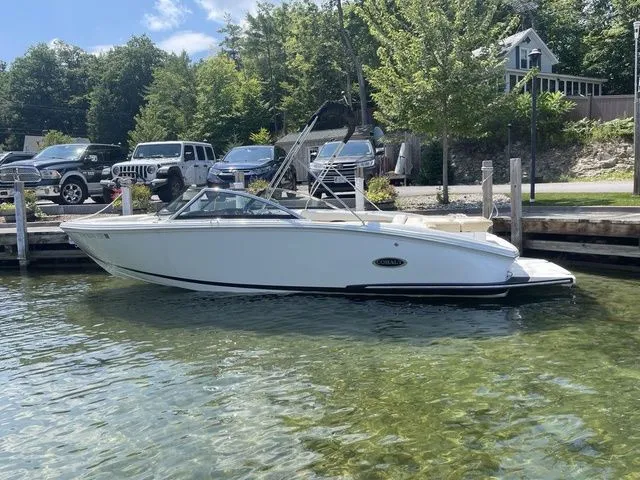 Slide: The Image of 2022 Cobalt CS23 boat docked in clear water, surrounded by trees and parked cars. - 4