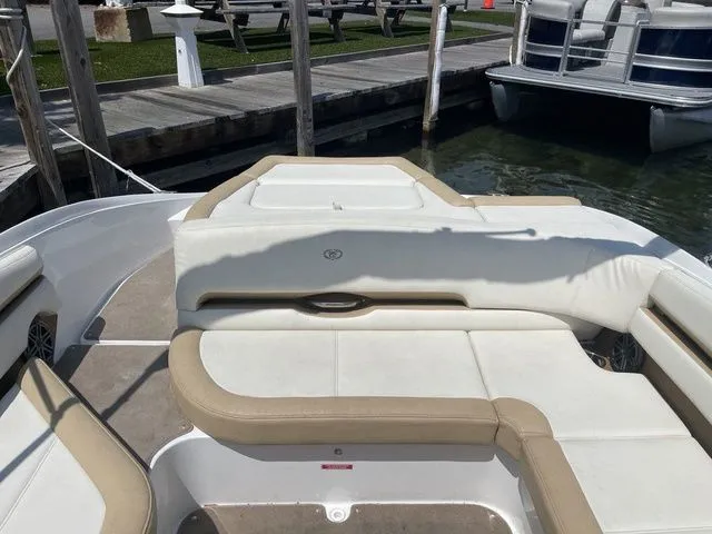 Slide: The Image of 2022 Cobalt CS23 boat interior with beige and white seating at a dock. - 5