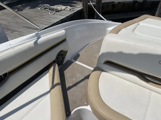 Slide: The Image of 2022 Cobalt CS23 boat interior with beige and white seating, docked at a wooden pier. - 6