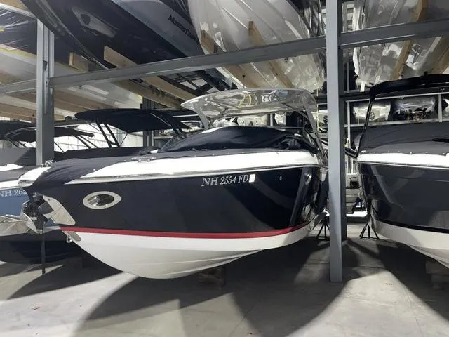 Slide: The Image of 2019 Cobalt R30 boat in storage, black hull, covered, surrounded by other boats. - 15