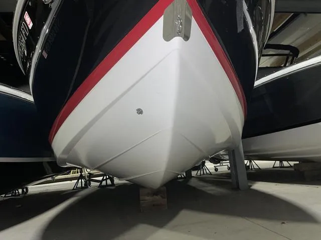 Slide: The Image of 2019 Cobalt R30 boat in storage, showcasing sleek hull design and vibrant red stripe. - 16
