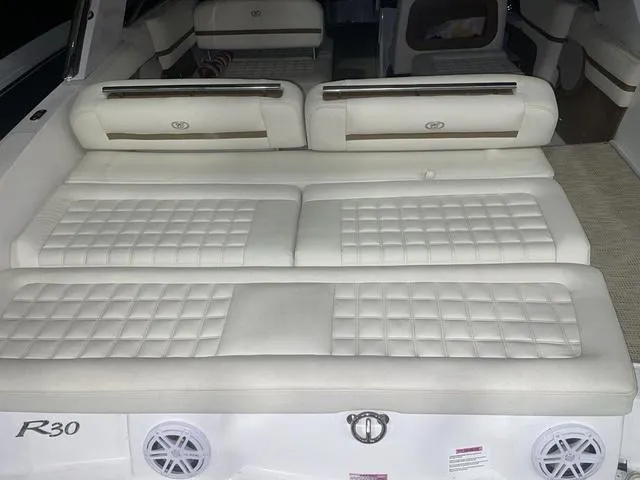 Slide: The Image of 2019 Cobalt R30 boat interior with white cushioned seating and speaker system. - 28