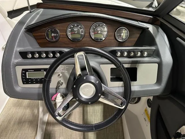Slide: The Image of Steering wheel and dashboard of a 2014 Cobalt R3 boat, featuring gauges and controls. - 6
