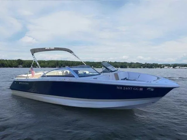 Slide: The Image of 2015 Four Winns H230 boat on a lake, featuring a sleek blue and white design. - 1