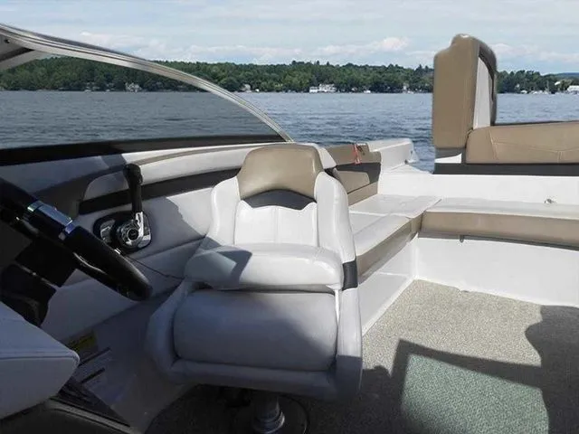 Slide: The Image of Interior of 2015 Four Winns H230 boat with seating and steering wheel, on a lake. - 13