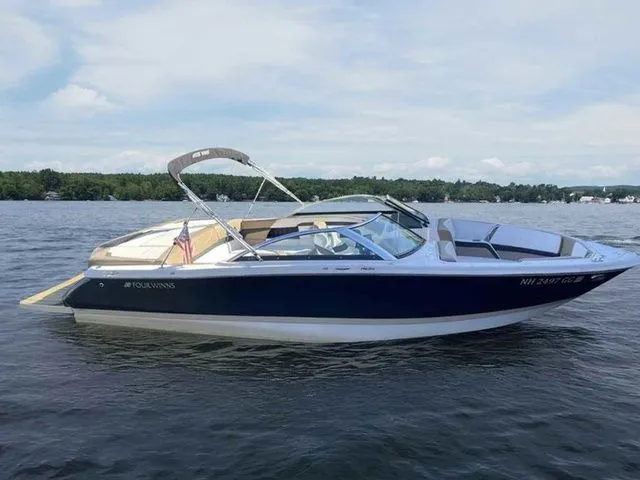 Slide: The Image of 2015 Four Winns H230 boat on a lake, featuring sleek design and canopy. - 5