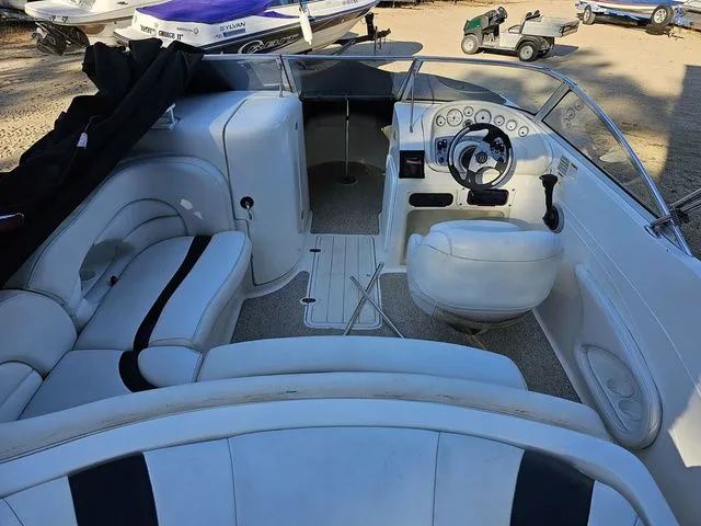 Slide: The Image of 2004 Sylvan 2080 I/O boat interior with white seating and steering wheel. - 2