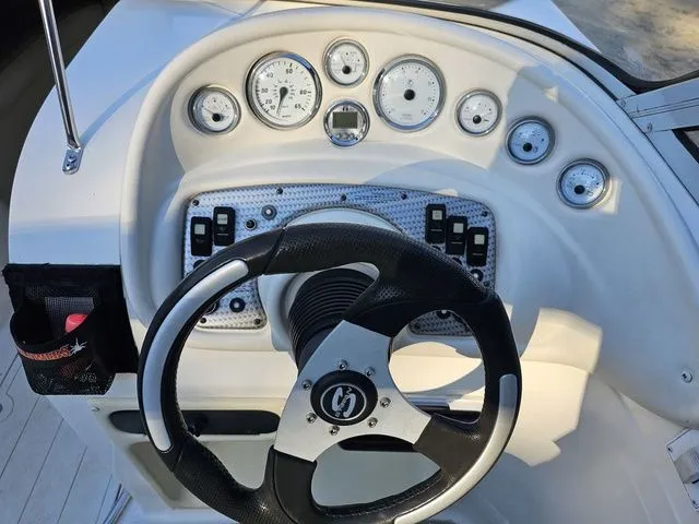 Slide: The Image of Steering wheel and dashboard of a 2004 Sylvan 2080 I/O boat with gauges and controls. - 4