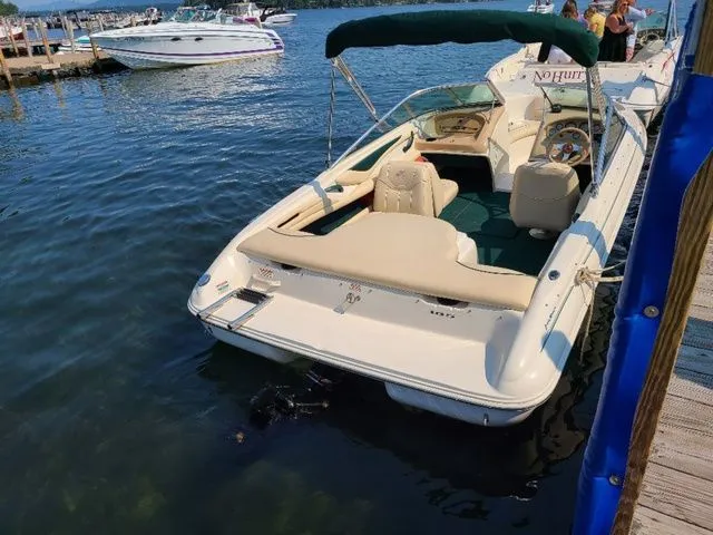 Slide: The Image of 2000 Sea Ray 185BR boat docked on a sunny day, featuring beige seating and green canopy. - 3
