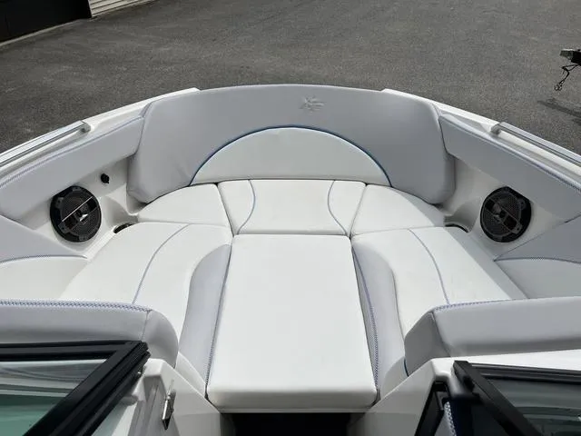 Slide: The Image of 2021 MasterCraft XT22 boat interior with white cushioned seating and built-in speakers. - 13
