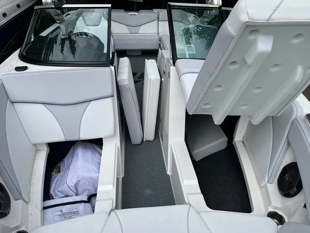 Slide: The Image of 2021 MasterCraft XT22 boat interior with open storage compartments and white seating. - 14