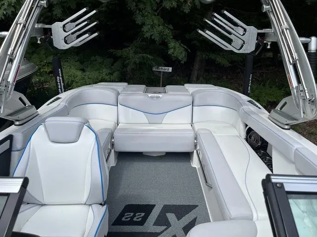Slide: The Image of 2021 MasterCraft XT22 boat interior with white seating and wakeboard racks. - 15