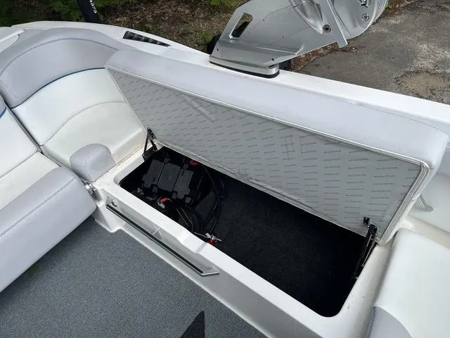Slide: The Image of 2021 MasterCraft XT22 boat storage compartment with open lid, revealing interior space. - 18