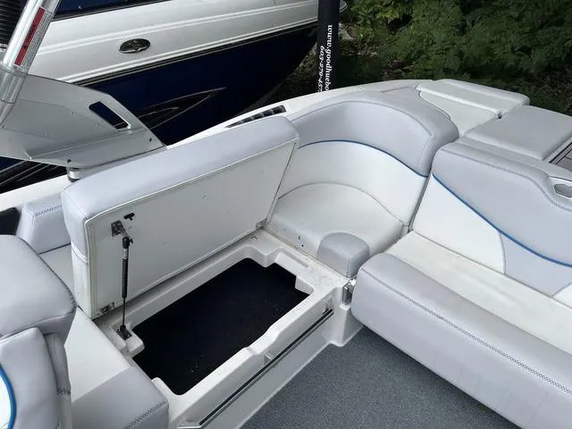 Slide: The Image of 2021 MasterCraft XT22 boat interior with open storage compartment, white and gray seating. - 21