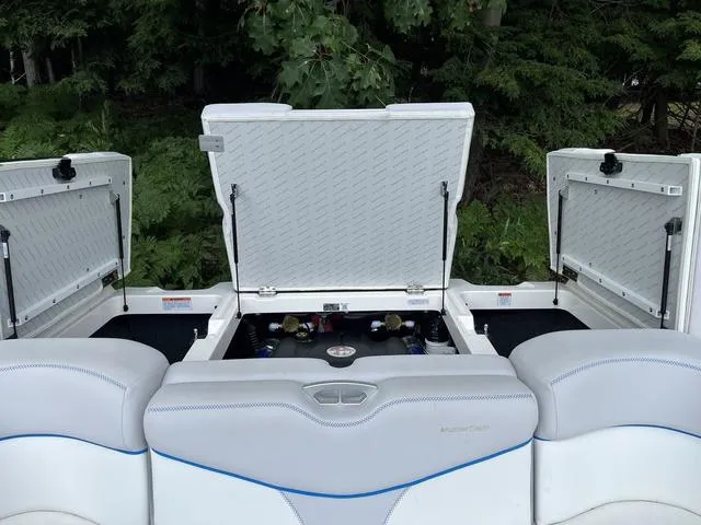 Slide: The Image of 2021 MasterCraft XT22 boat with open storage compartments, showcasing interior design and seating. - 22