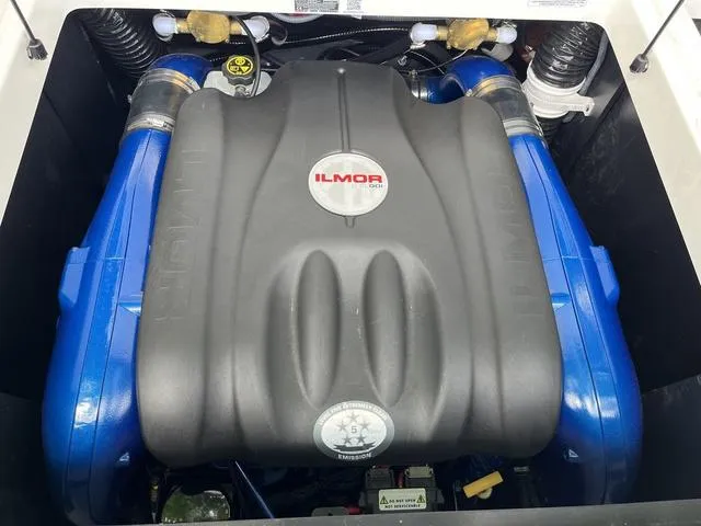 Slide: The Image of 2021 MasterCraft XT22 Ilmor engine with blue accents in boat compartment. - 25